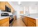 Well-lit kitchen with stainless steel appliances, bright countertops and wood cabinets for a modern look at 4412 Red Blanket Rd, North Las Vegas, NV 89032