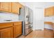 Close-up of a stainless-steel refrigerator and wood cabinets creating a functional kitchen space at 4412 Red Blanket Rd, North Las Vegas, NV 89032