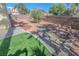 Landscaped backyard featuring a retaining wall, artificial turf, desert foliage, and rock beds at 4416 Inez Dr, Las Vegas, NV 89130