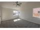 Spacious bedroom featuring plush carpet, a ceiling fan, and large windows for natural light at 4416 Inez Dr, Las Vegas, NV 89130