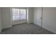 Cozy bedroom with plush carpet, a large window with blinds, and a white door at 4416 Inez Dr, Las Vegas, NV 89130