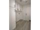 Bright laundry room with white cabinetry and laminate flooring near a white door at 4416 Inez Dr, Las Vegas, NV 89130