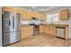 Updated kitchen featuring wood floors, light wood cabinets, granite countertops, and stainless steel appliances at 4430 Eureka Cir, Las Vegas, NV 89103