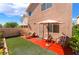 Backyard featuring artificial grass, patio with seating, and outdoor grilling area at 4515 Sandstone Vista Ct, North Las Vegas, NV 89031