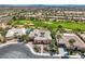 Aerial view of home with solar panels, landscaping, golf course and city views at 4980 Pensier St, Las Vegas, NV 89135