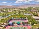 Extensive aerial view showcasing tennis courts, a golf course, and picturesque mountain views at 4980 Pensier St, Las Vegas, NV 89135