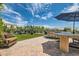 Picturesque backyard with patio seating, outdoor grill, artificial turf, and manicured hedges in a private setting at 4980 Pensier St, Las Vegas, NV 89135