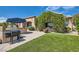 Inviting backyard with covered patio, outdoor grill, artificial turf and lush vines covering the exterior wall at 4980 Pensier St, Las Vegas, NV 89135