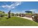 Serene backyard featuring a custom outdoor grill, artificial turf, an umbrella, and desert landscaping at 4980 Pensier St, Las Vegas, NV 89135