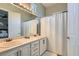 Bright bathroom with a double sink vanity, large mirror and shower with curtain at 4980 Pensier St, Las Vegas, NV 89135
