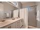 Bright bathroom with dual sinks, white cabinets, and a glass enclosed shower at 4980 Pensier St, Las Vegas, NV 89135