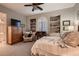 Bright bedroom with a ceiling fan, a built-in bookcase, a desk, a dresser, and neutral carpet at 4980 Pensier St, Las Vegas, NV 89135
