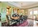 Formal dining room with a large wood table, elegant chandelier, and views of the outdoors at 4980 Pensier St, Las Vegas, NV 89135