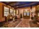 Inviting home entrance with a covered patio featuring decorative statues, desert-themed landscaping, and a beautiful double door at 4980 Pensier St, Las Vegas, NV 89135