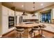 Spacious kitchen with a large granite island, stainless steel appliances, custom cabinetry and hardwood floors at 4980 Pensier St, Las Vegas, NV 89135