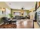Inviting living room featuring hardwood floors, a ceiling fan, large windows, and comfortable seating at 4980 Pensier St, Las Vegas, NV 89135