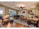 Cozy living room features hardwood floors, a tray ceiling, neutral paint, stylish furniture, and a piano at 4980 Pensier St, Las Vegas, NV 89135