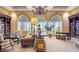 Elegant living room with large arched windows, bookshelves, and classic furnishings at 4980 Pensier St, Las Vegas, NV 89135