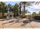Outdoor patio area with fireplace, seating, and views of lush landscaping and palm trees at 4980 Pensier St, Las Vegas, NV 89135
