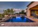 Backyard pool area features a brick-laid patio, a cascading waterfall and access to the home's covered patio and outdoor living space at 4980 Pensier St, Las Vegas, NV 89135
