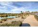 Scenic view of a walking path by the pond in a golf course community with landscaping at 4980 Pensier St, Las Vegas, NV 89135