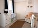 Cozy Bedroom features crib, plush chair, changing table and animal themed wall decorations at 5541 Alvarez St, North Las Vegas, NV 89031