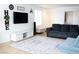 Bright living room featuring a plush sofa, entertainment center, and stylish area rug at 5541 Alvarez St, North Las Vegas, NV 89031