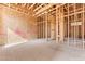 Unfinished bedroom 3 reveals wood framing, a concrete slab, and abundant natural light ready for customization at 5885 St Ebbes Ct, Las Vegas, NV 89131