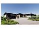 Gorgeous home with a blend of modern architecture and lush desert landscaping at 5885 St Ebbes Ct, Las Vegas, NV 89131