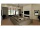 Elegant living room with a large gray sectional sofa, modern fireplace, and floor-to-ceiling windows offering outdoor views at 5885 St Ebbes Ct, Las Vegas, NV 89131