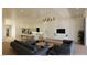 Open-concept living space with a modern kitchen, cozy living area, and marble accent wall with a mounted TV at 5885 St Ebbes Ct, Las Vegas, NV 89131