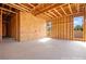 The unfinished primary bedroom displays wood framing, large windows, and natural light awaiting personalization at 5885 St Ebbes Ct, Las Vegas, NV 89131