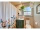 Bathroom featuring a charming vanity, floral shower curtain, and a bright window at 604 I, Boulder City, NV 89005
