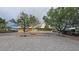 Home exterior with mature trees, gravel landscaping, and a covered porch at 6460 Wagon Wheel Ct, Pahrump, NV 89061