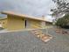 Exterior view of home with gravel landscaping, steps and mature trees at 6460 Wagon Wheel Ct, Pahrump, NV 89061