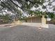 Exterior of the home featuring a covered porch, gravel landscaping, and mature trees at 6460 Wagon Wheel Ct, Pahrump, NV 89061