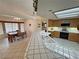 Spacious kitchen with white tiled counter tops and adjacent breakfast nook at 6460 Wagon Wheel Ct, Pahrump, NV 89061
