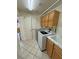 Functional laundry area with washer, dryer, utility sink, and wooden cabinets at 6460 Wagon Wheel Ct, Pahrump, NV 89061