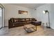 A bright condo living room featuring a comfortable leather sofa, stylish decor and wood-look floors at 6480 Annie Oakley Dr # 314, Las Vegas, NV 89120