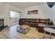 Comfortable condo living room with a large leather sofa, modern decor, and access to a private balcony at 6480 Annie Oakley Dr # 314, Las Vegas, NV 89120