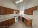 Functional kitchen with wooden cabinets, white countertops, and modern appliances providing a practical cooking space at 6512 Sterling Springs Pkwy, Las Vegas, NV 89108