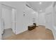 Neutral hallway with white walls, a bench, and multiple doors leading to various rooms at 6631 Creeping Thyme St, Las Vegas, NV 89148