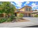 Well-maintained front yard with mature trees and shrubbery, complemented by a neutral stucco exterior and three-car garage at 6713 Guidestar St, North Las Vegas, NV 89084