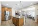 Open-concept kitchen boasts stainless steel appliances, wooden cabinets, and a granite-topped island for meal prep at 6713 Guidestar St, North Las Vegas, NV 89084