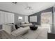 Bright, modern living room with a ceiling fan, light gray colored walls and wood-style laminate flooring at 71 Blaven Dr, Henderson, NV 89002