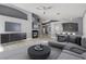Modern living room with a fireplace, gray sofa, dark-toned console and a stylish light fixture and decor at 71 Blaven Dr, Henderson, NV 89002