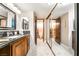 Bathroom showcasing granite countertop, wooden cabinets, and a mirrored closet for added convenience at 750 S Royal Crest Cir # 317, Las Vegas, NV 89169