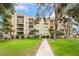 Exterior view of a multi-story condo building set on a green lawn at 750 S Royal Crest Cir # 317, Las Vegas, NV 89169