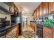 Galley kitchen featuring warm wood cabinetry, granite countertops, and neutral tile flooring with appliances at 750 S Royal Crest Cir # 317, Las Vegas, NV 89169