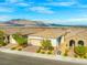 An aerial view of a desert home showcases mountain views, tiled roof, and low-maintenance landscaping at 8668 Marcana St, Las Vegas, NV 89166